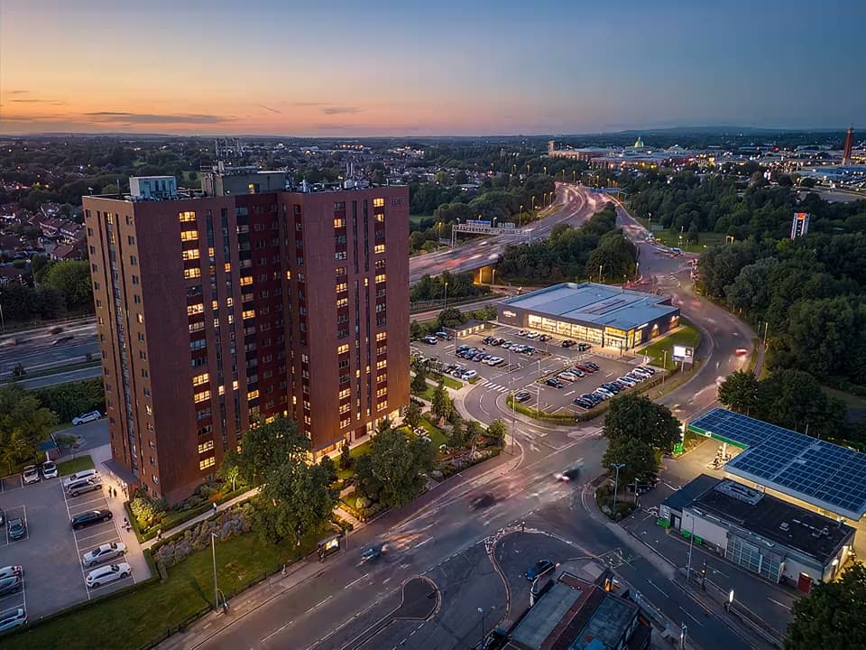 Aerial view of One Trafford Edge at dusk beside the Trafford Centre